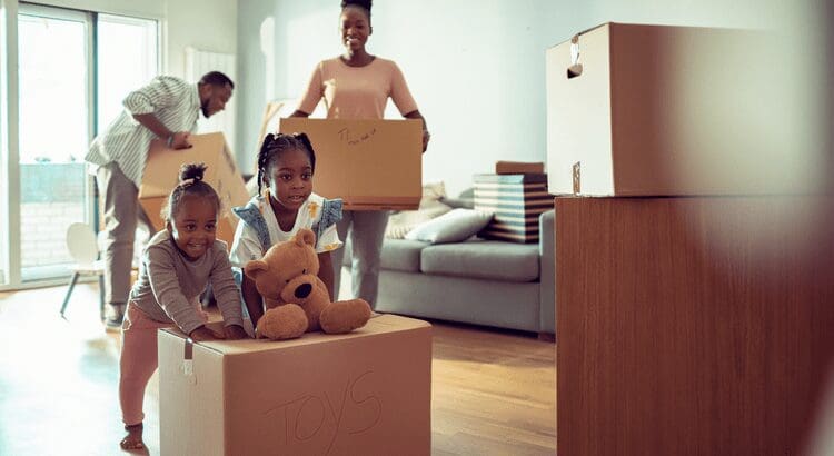 Family moving with children and cardboard boxes.