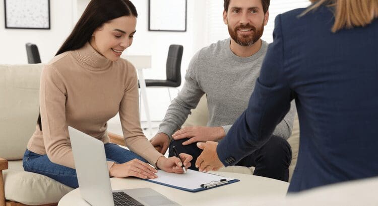 Couple signing documents with an advisor.