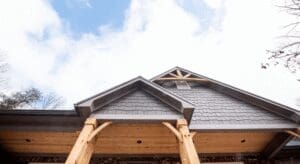 House roof with wooden beams and sky.