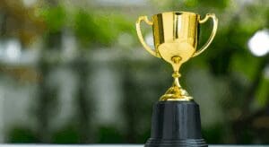 Gold trophy on a black base outdoors.