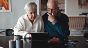 Elderly couple using tablet at home.