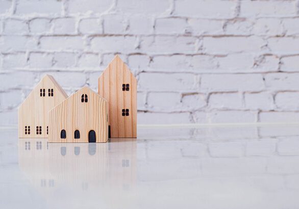 A wooden model of houses sitting on top of a table.