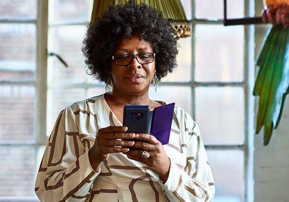 Woman in her 50s wearing glasses, using cell phone, mobile technology, communication, connections