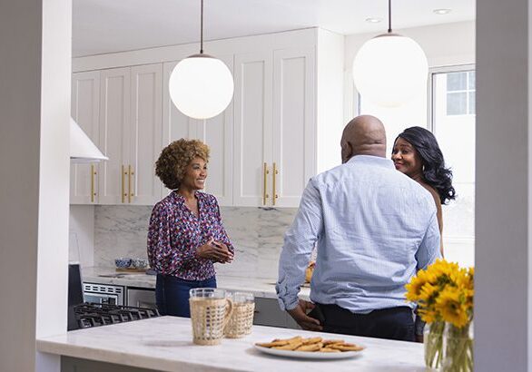 Female real estate agent talking to couple while standing in kitchen of new house