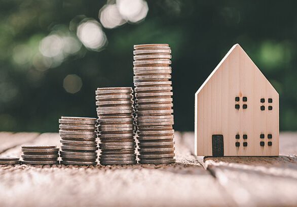 Investment in the real estate business. Money coin stack growing graph and wood house model. Loans for the purchase of residential houses. Save for the future.
