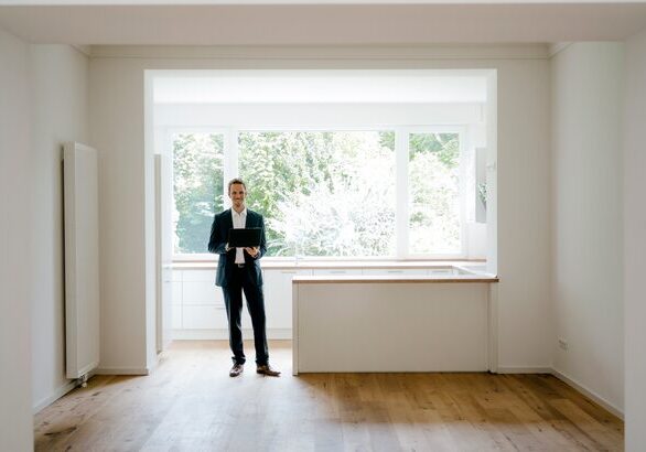 A man standing in front of an open window.