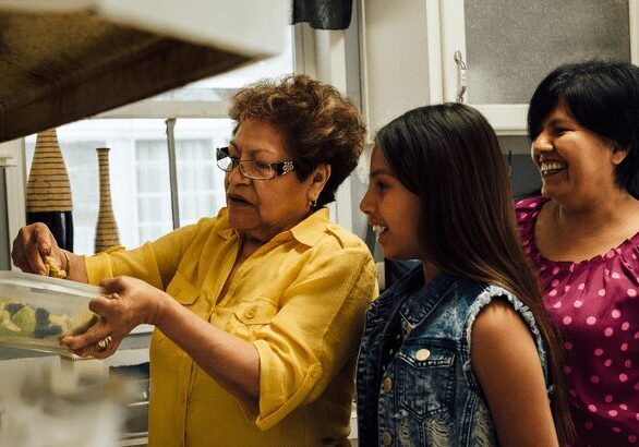 Three women cooking together in the kitchen.