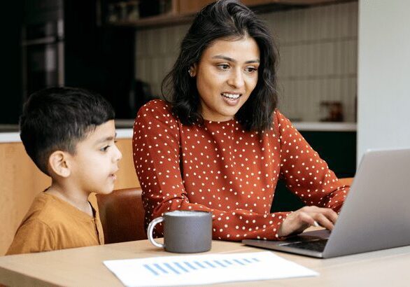 Woman and child using a laptop together.