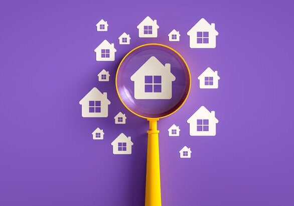 Magnifying glass over small house icons.