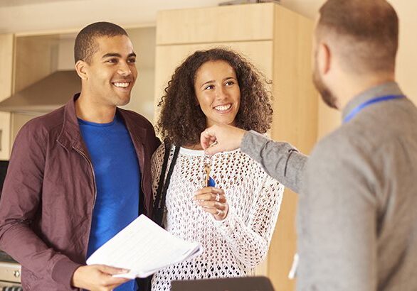 a young couple receive the keys to their new apartment from a letting agent.