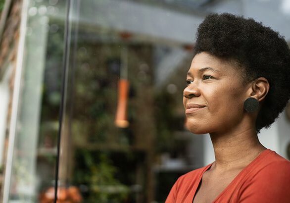 A woman with an afro looking out of the window.
