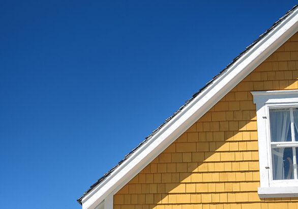 Architectural detail of an old yellow house on a sunny day.
