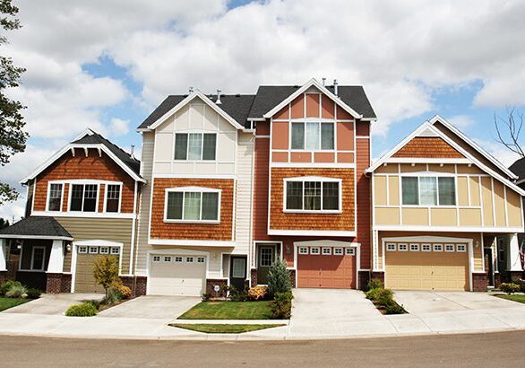 A row of houses with garage doors on the side.
