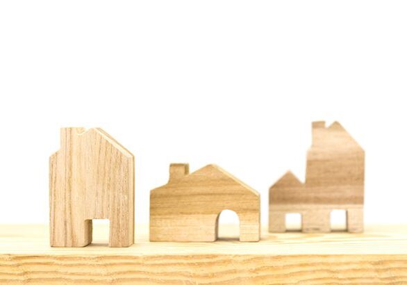 A wooden model of houses on top of a shelf.