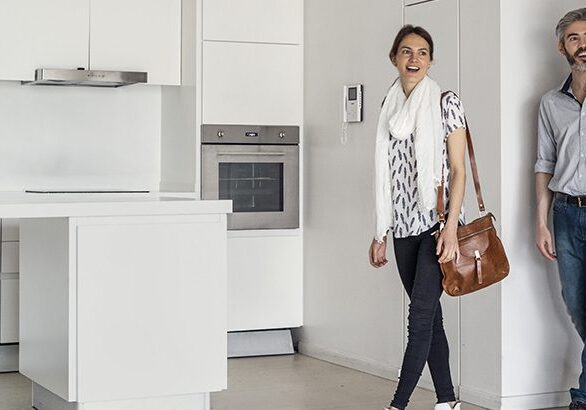 A woman walking in the kitchen with her purse